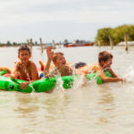 Kinder baden im See mit einer Luftmatratze